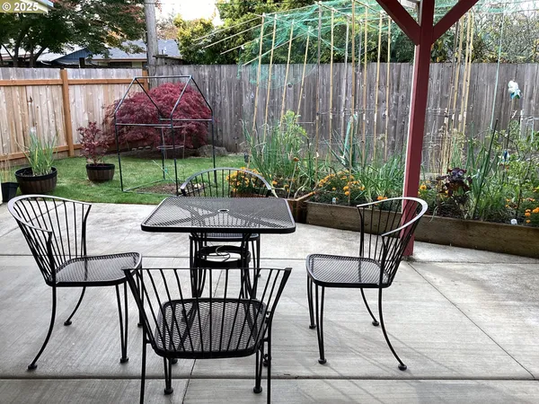a view of a chairs and table in back yard of a house