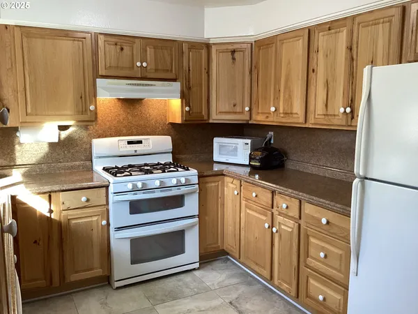 a kitchen with stainless steel appliances granite countertop a refrigerator stove and sink