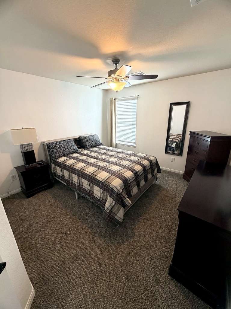18623 Dingo Stream Lane Katy, TX 77449 - Photo 29 of 29 a bedroom with bed and a chandelier