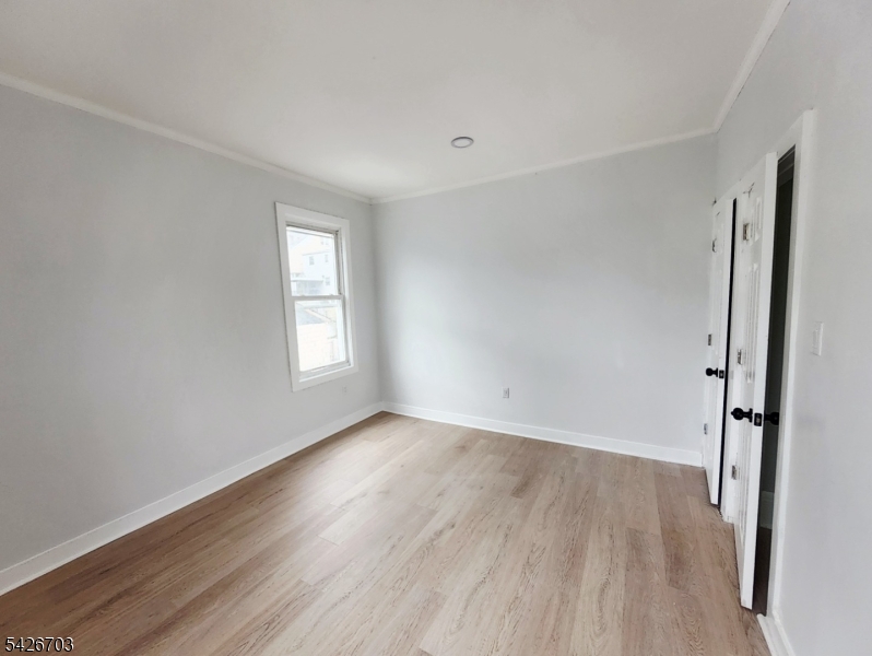 49 Union Place, Unit 3 Irvington, NJ 07111 - Photo 11 of 20 a view of an empty room with wooden floor and a window