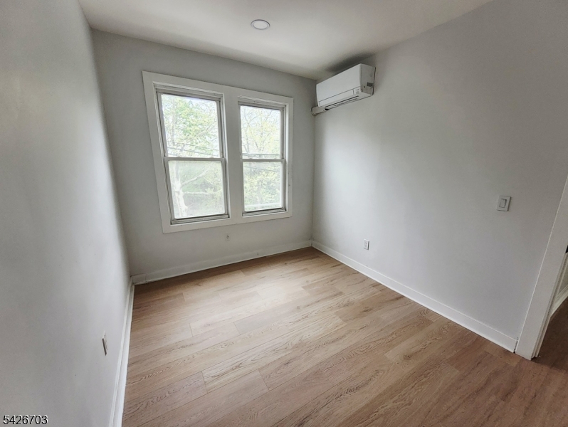 49 Union Place, Unit 3 Irvington, NJ 07111 - Photo 17 of 20 an empty room with wooden floor and windows