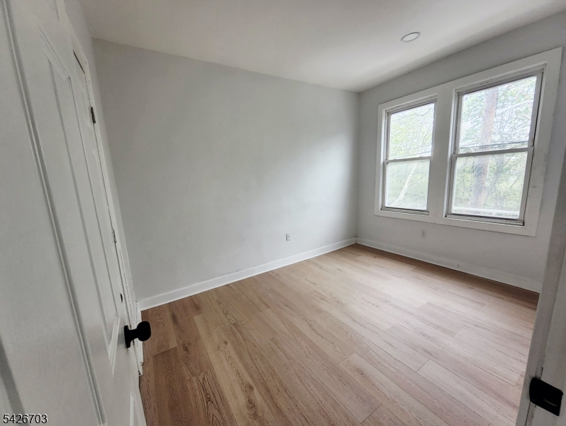 49 Union Place, Unit 3 Irvington, NJ 07111 - Photo 18 of 20 an empty room with wooden floor and windows