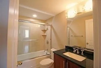 a bathroom with a sink a toilet a mirror and shower