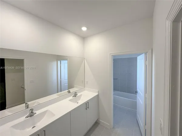 a bathroom with a double vanity sink and a mirror
