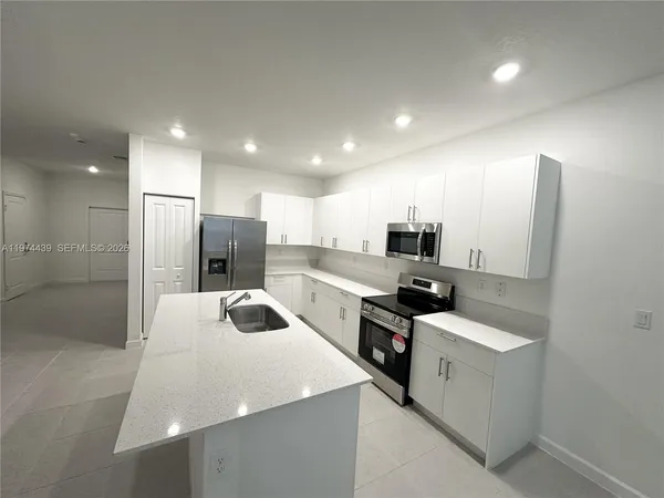 a kitchen with stainless steel appliances a refrigerator and a sink