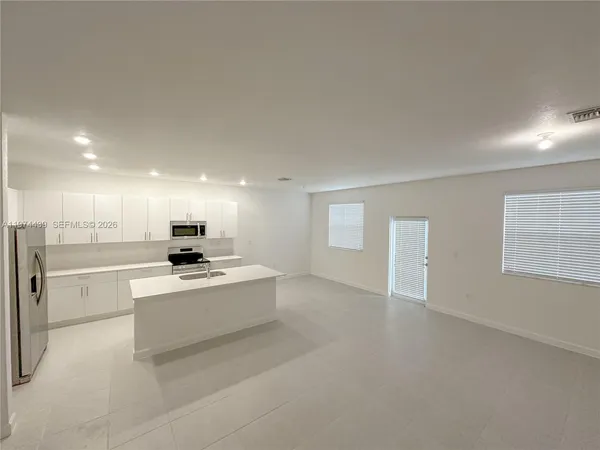 a view of kitchen with stove and refrigerator