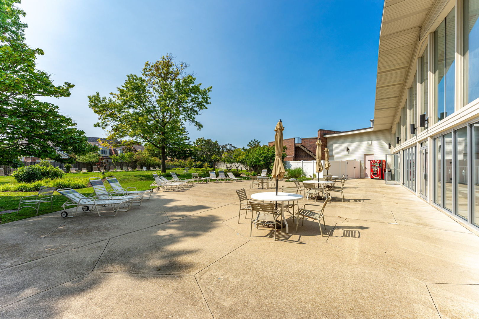 701 Forum Square, Unit 101 Glenview, IL 60025 - Photo 40 of 42 a view of a patio with a table and chairs under an umbrella with wooden fence
