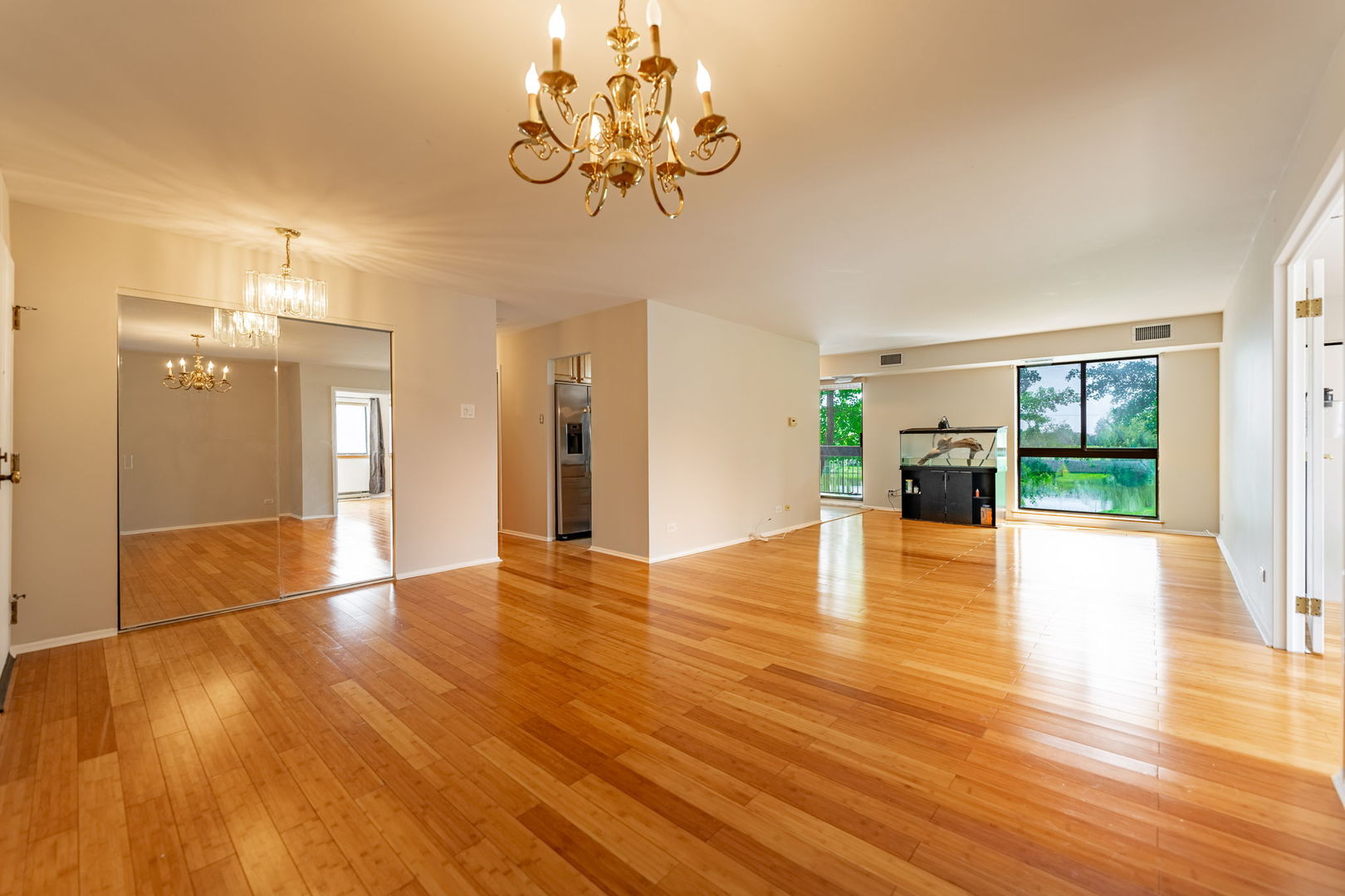 701 Forum Square, Unit 101 Glenview, IL 60025 - Photo 4 of 42 a view of an empty room with wooden floor and a kitchen