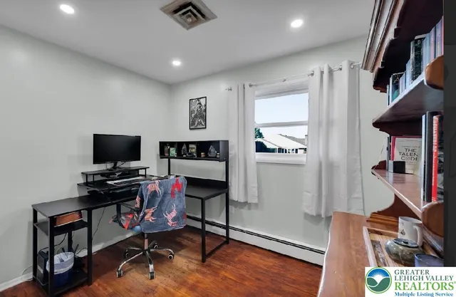 a view of a workspace with furniture and a window