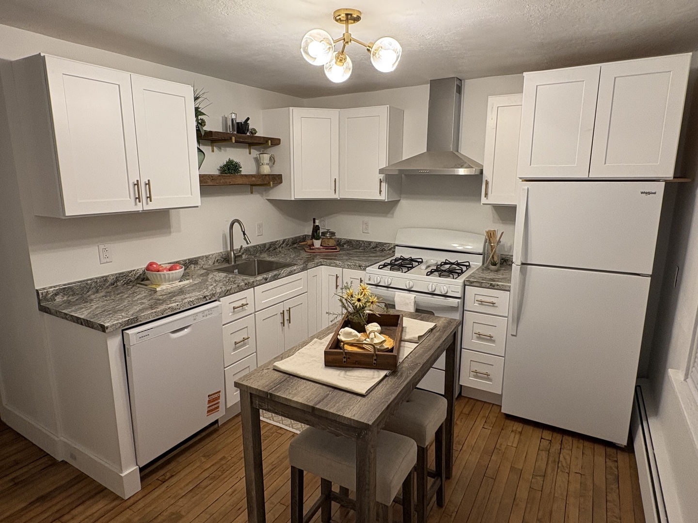 116 North 9th Street DeKalb, IL 60115 - Photo 9 of 20 a kitchen with granite countertop a refrigerator a stove a sink dishwasher and white cabinets with wooden floor