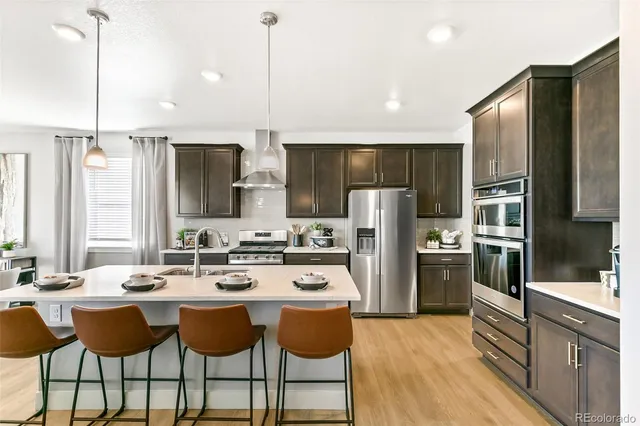 a kitchen with refrigerator cabinets and chairs