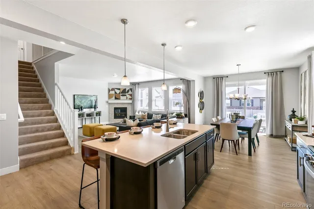 a view of a dining room and livingroom with furniture wooden floor a chandelier