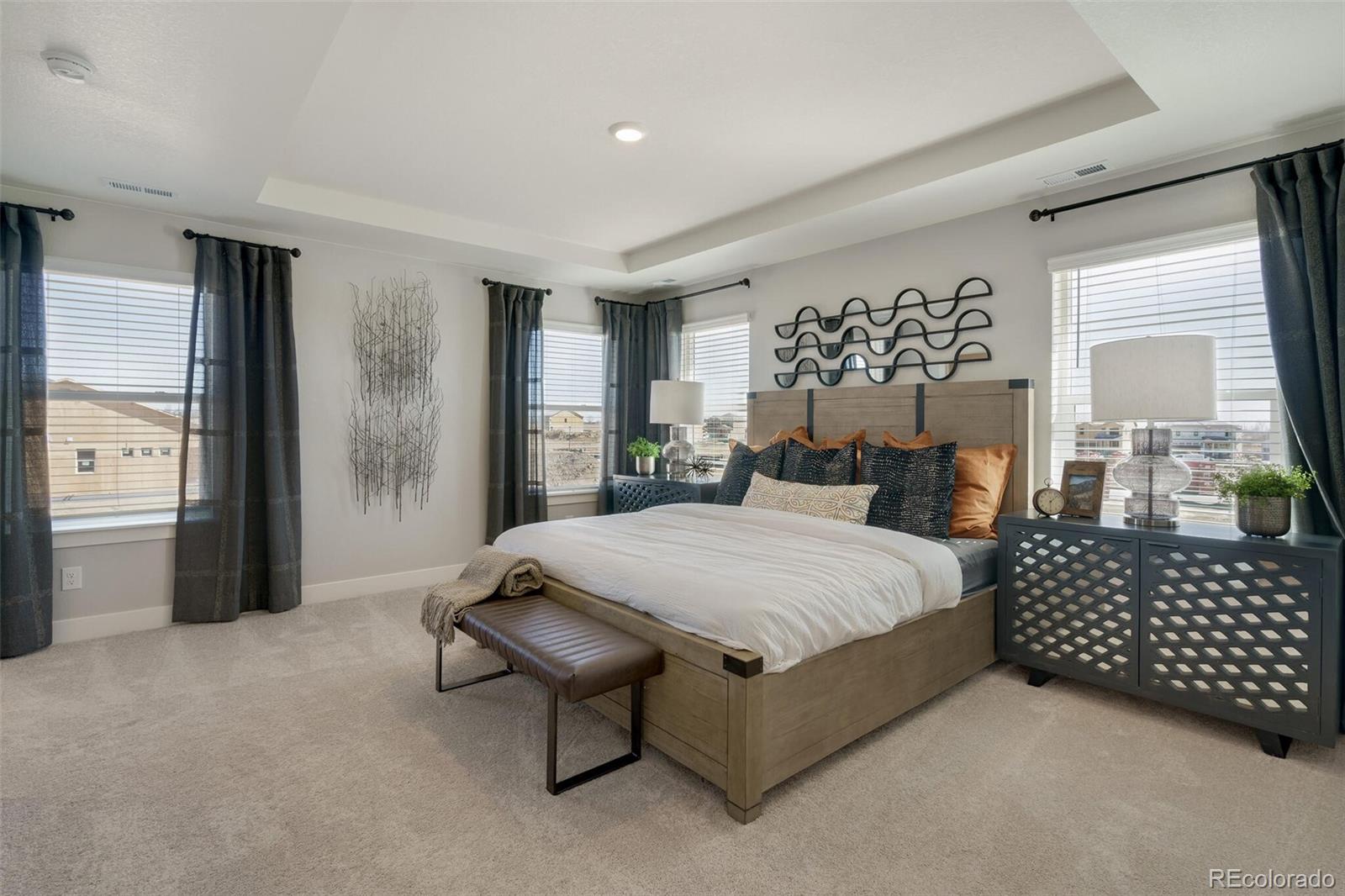 1908 Chaffee Crest Drive Berthoud, CO 80513 - Photo 19 of 39 a spacious bedroom with a bed and a chandelier