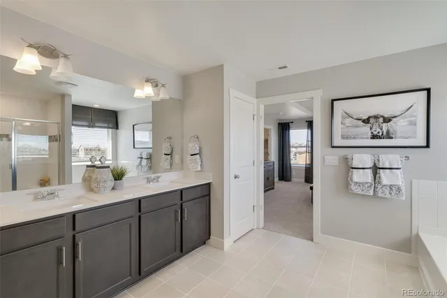 a en suite bathroom with a double vanity sink and a mirror