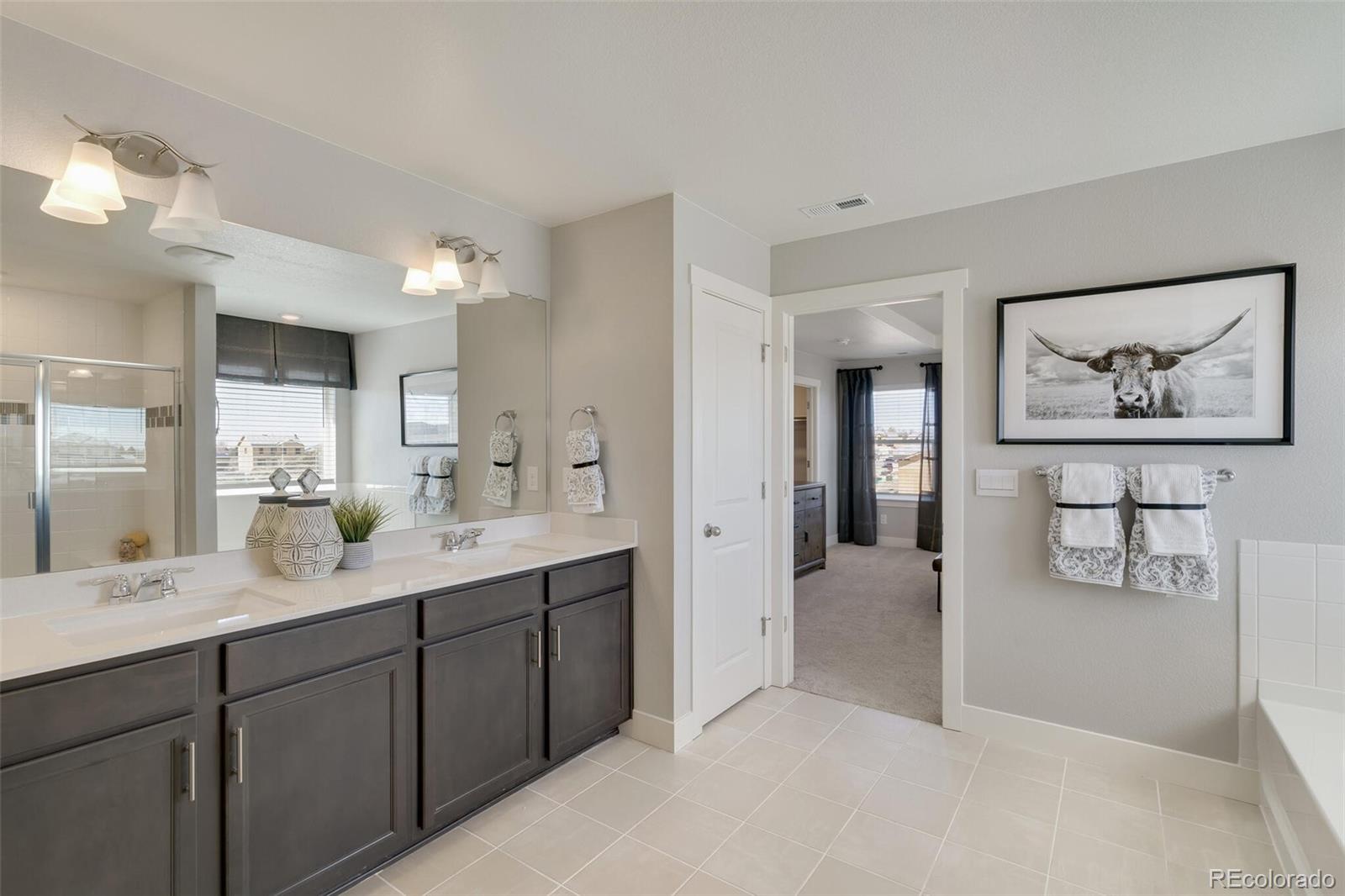 1908 Chaffee Crest Drive Berthoud, CO 80513 - Photo 22 of 39 a en suite bathroom with a double vanity sink and a mirror