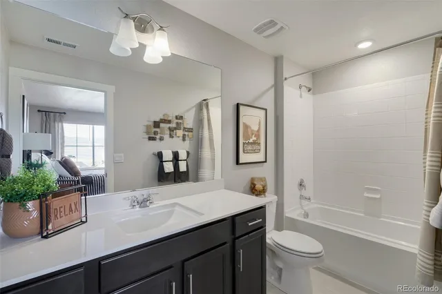 a bathroom with a double vanity sink toilet and shower