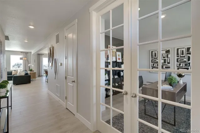 a view of a hallway with wooden floor and windows