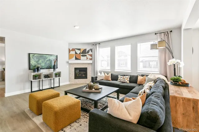 a living room with furniture fireplace and a large window
