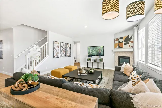 a living room with furniture flowerpot and wooden floor