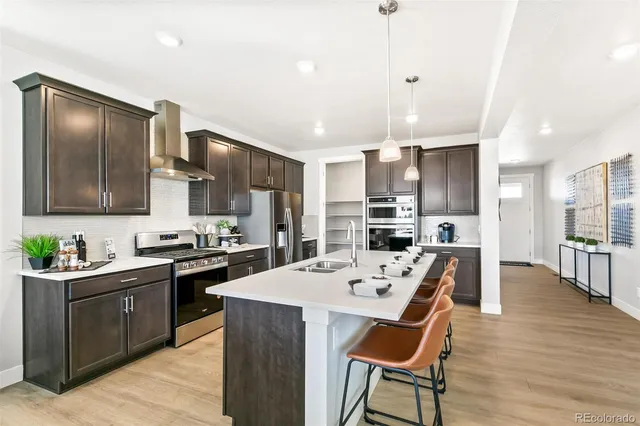 a kitchen with stainless steel appliances a sink stove and refrigerator