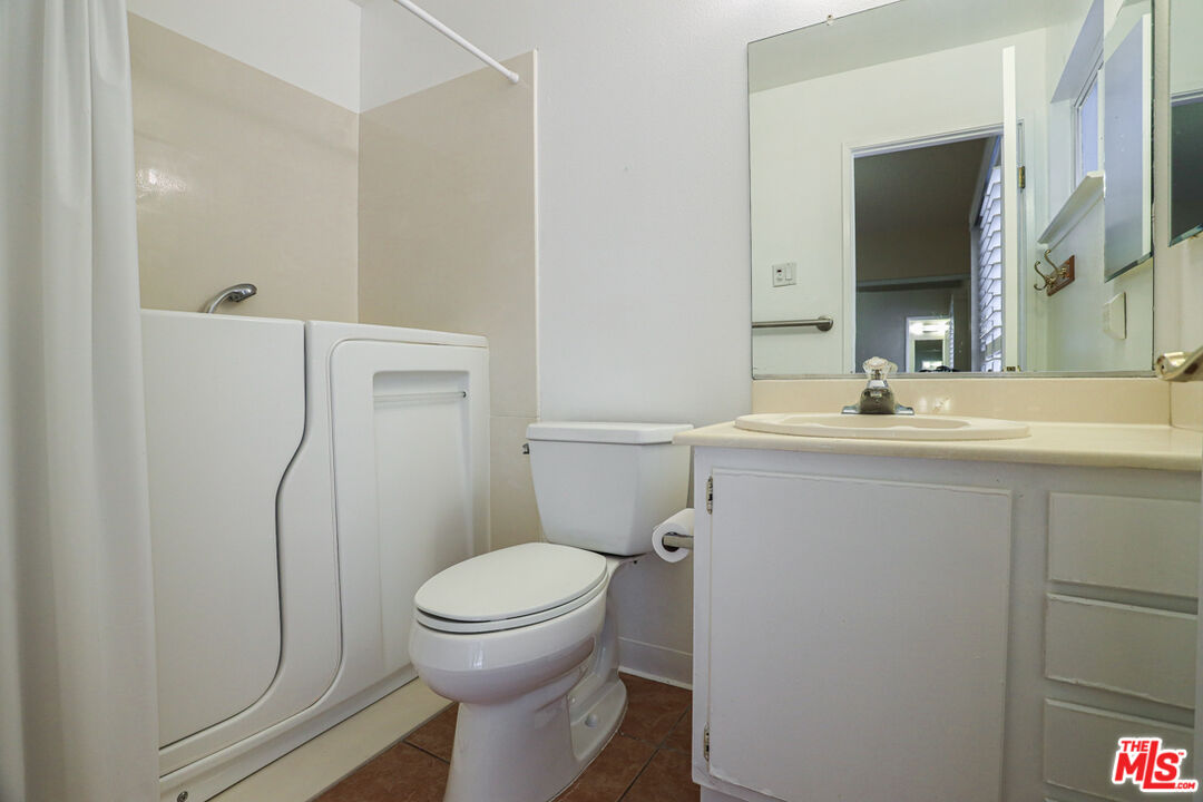6811 Wilding Place Riverside, CA 92506 - Photo 16 of 42 a bathroom with a granite countertop toilet sink and a mirror