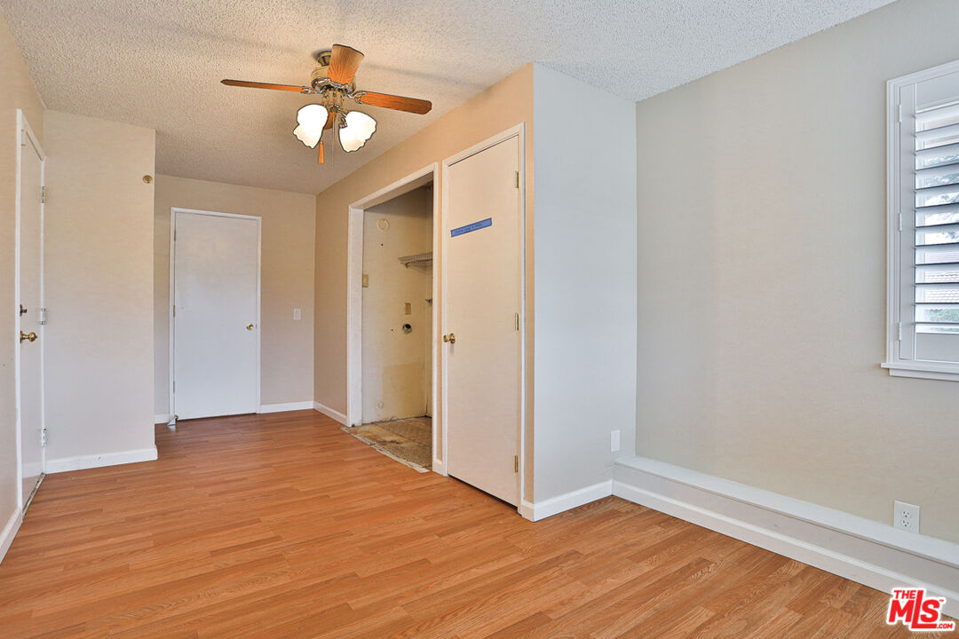6811 Wilding Place Riverside, CA 92506 - Photo 19 of 42 an empty room with wooden floor fan and windows