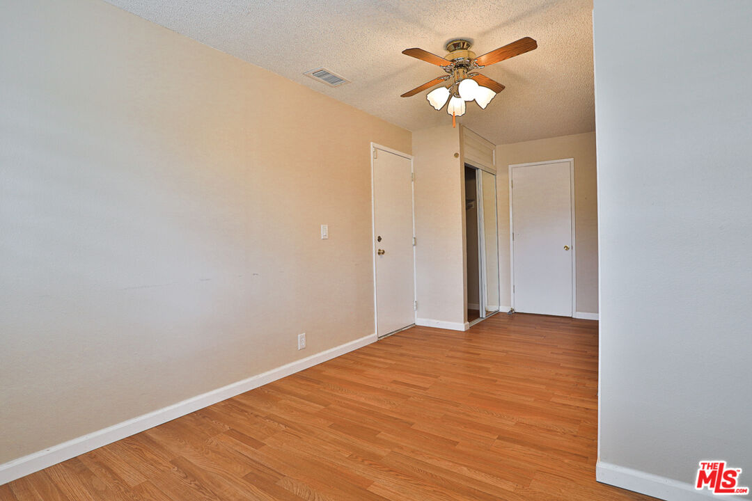 6811 Wilding Place Riverside, CA 92506 - Photo 20 of 42 a view of a room with a ceiling fan and wooden floor