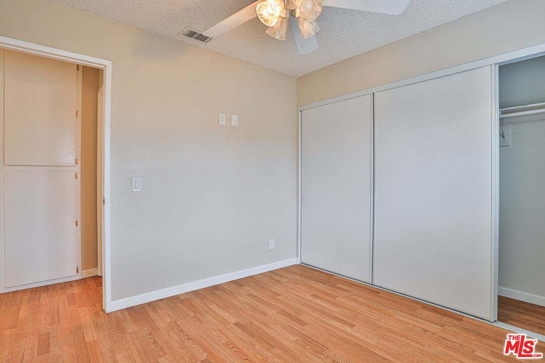 6811 Wilding Place Riverside, CA 92506 - Photo 25 of 42 an empty room with wooden floor fan and windows