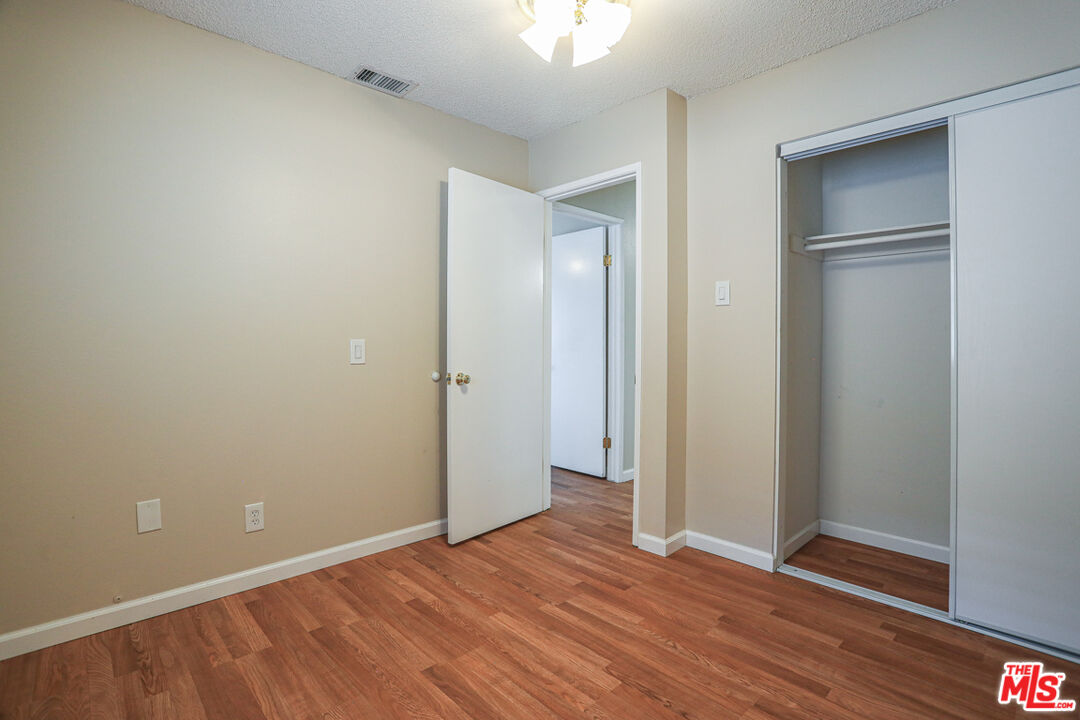 6811 Wilding Place Riverside, CA 92506 - Photo 28 of 42 an empty room with wooden floor and closet