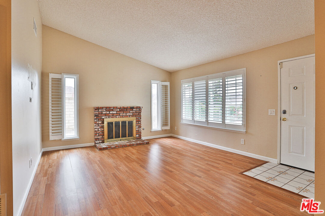 6811 Wilding Place Riverside, CA 92506 - Photo 4 of 42 a view of an empty room with a window and wooden floor