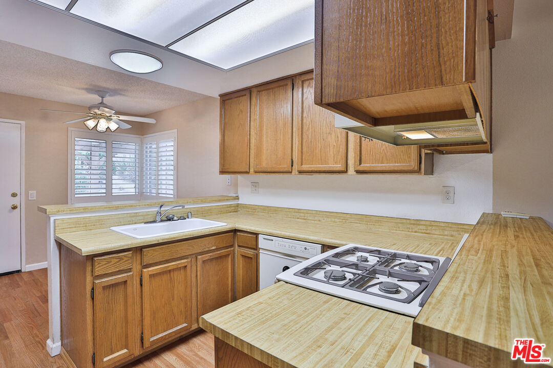 6811 Wilding Place Riverside, CA 92506 - Photo 10 of 42 a kitchen with a sink a stove cabinets and dining table