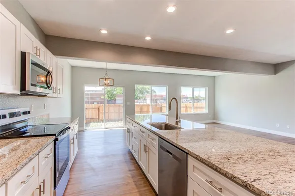 a large kitchen with kitchen island granite countertop a large counter top and a sink