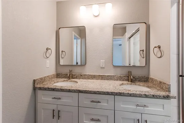 a bathroom with a granite countertop sink vanity and mirror