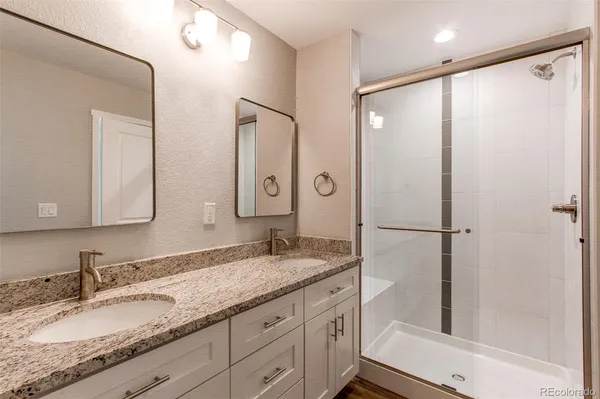 a bathroom with a granite countertop shower sink and mirror