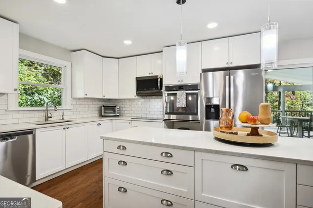a kitchen with stainless steel appliances white cabinets and a refrigerator