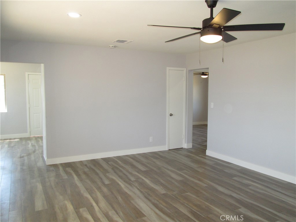 13464 Mohawk Road Apple Valley, CA 92308 - Photo 17 of 35 an empty room with wooden floor fan and windows