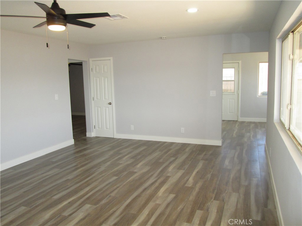13464 Mohawk Road Apple Valley, CA 92308 - Photo 21 of 35 an empty room with wooden floor fan and windows