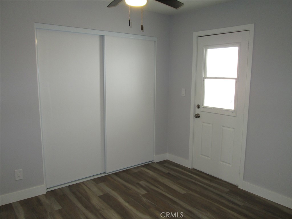 13464 Mohawk Road Apple Valley, CA 92308 - Photo 23 of 35 an empty room with wooden floor cabinet and windows