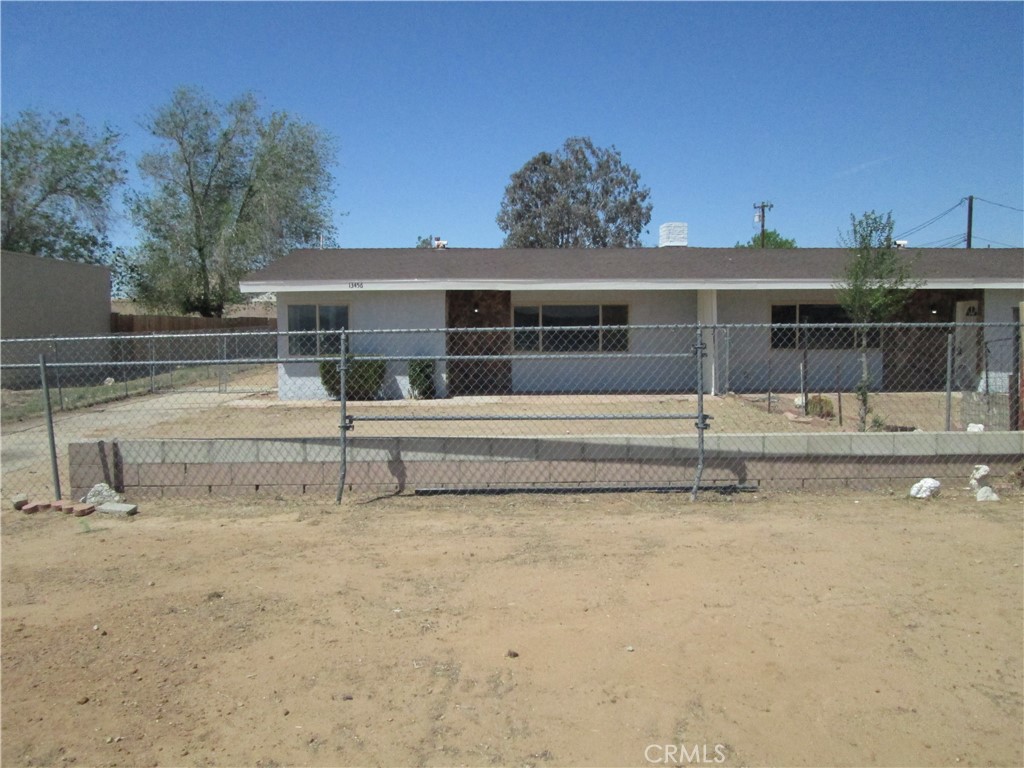 13464 Mohawk Road Apple Valley, CA 92308 - Photo 30 of 35 a view of a house with a small yard and a large tree