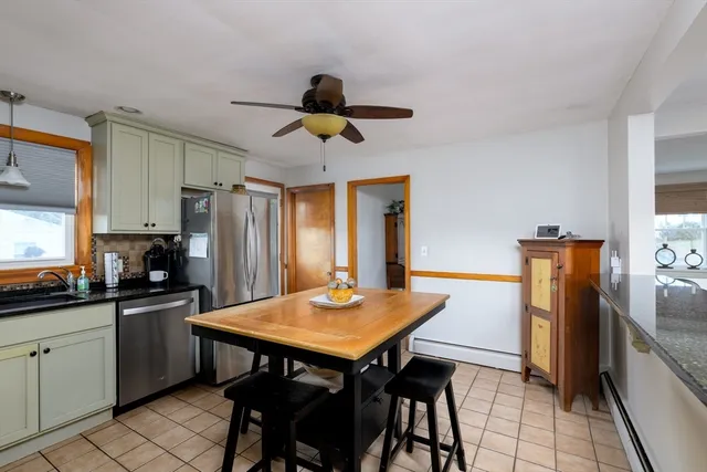 a kitchen with stainless steel appliances a table chairs and refrigerator
