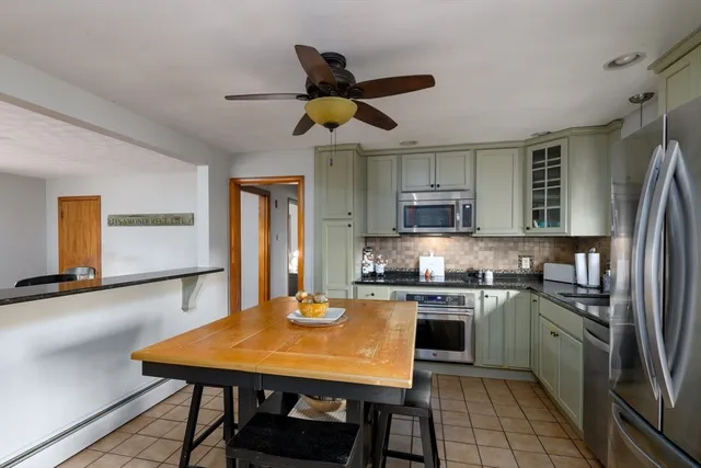 a kitchen with stainless steel appliances granite countertop a sink a stove counter space and cabinets