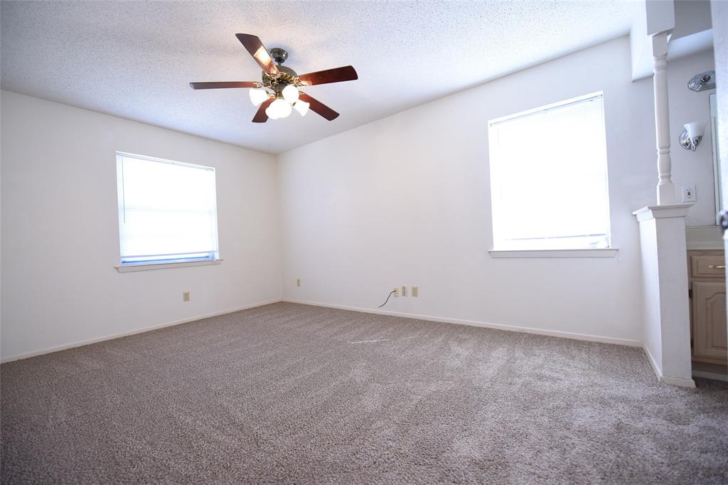 8945 Flicker Lane Dallas, TX 75238 - Photo 11 of 18 an empty room with a window and a ceiling fan