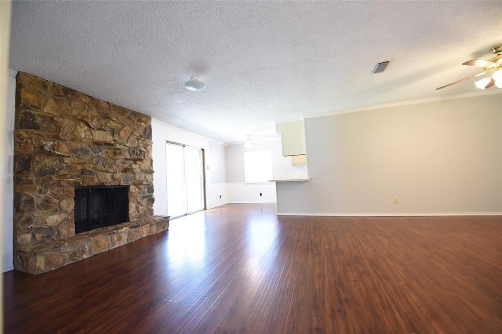 8945 Flicker Lane Dallas, TX 75238 - Photo 2 of 18 a view of empty room with wooden floor and fireplace