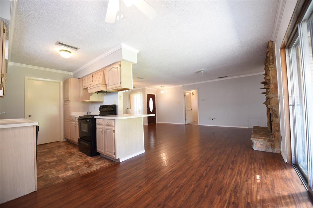 8945 Flicker Lane Dallas, TX 75238 - Photo 6 of 18 a kitchen with a refrigerator and wooden floor