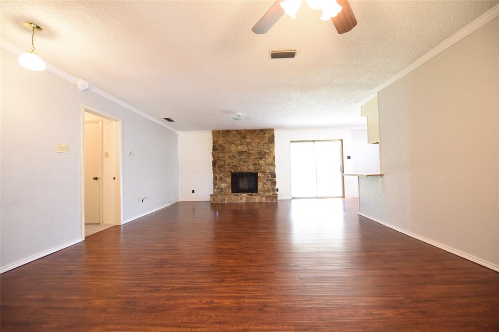 8945 Flicker Lane Dallas, TX 75238 - Photo 7 of 18 a view of a livingroom with wooden floor and a ceiling fan