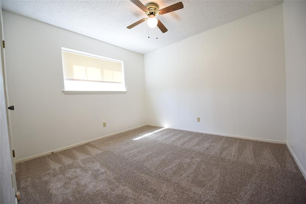 8945 Flicker Lane Dallas, TX 75238 - Photo 9 of 18 an empty room with a window and a fan