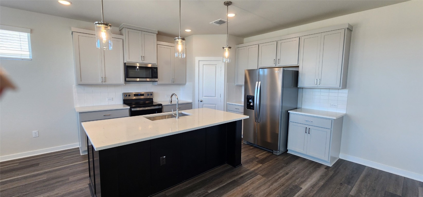 2220 Delano Drive Leander, TX 78641 - Photo 5 of 37 a kitchen with kitchen island a sink stainless steel appliances and cabinets