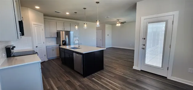 a kitchen with kitchen island a sink stainless steel appliances and cabinets