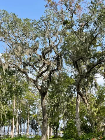 a view of a green field with wooden fence