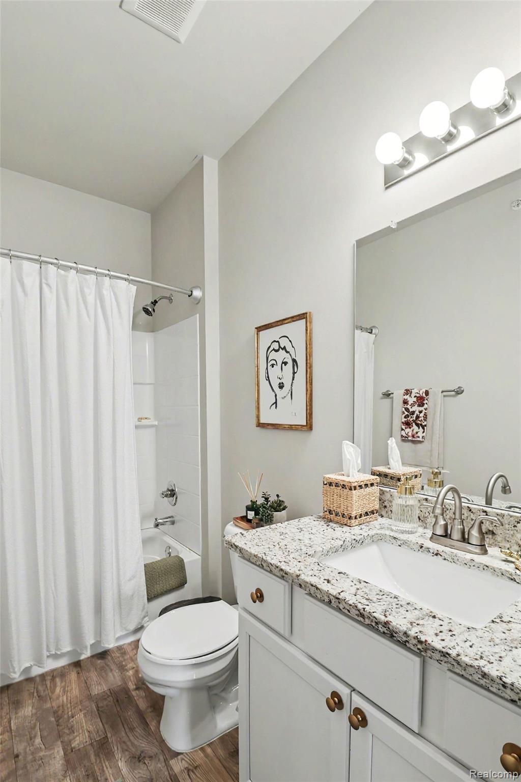 9864 Ridge Run Street Howell, MI 48855 - Photo 21 of 23 Bathroom with vanity, shower / bath combination with curtain, and dark wood-style floors